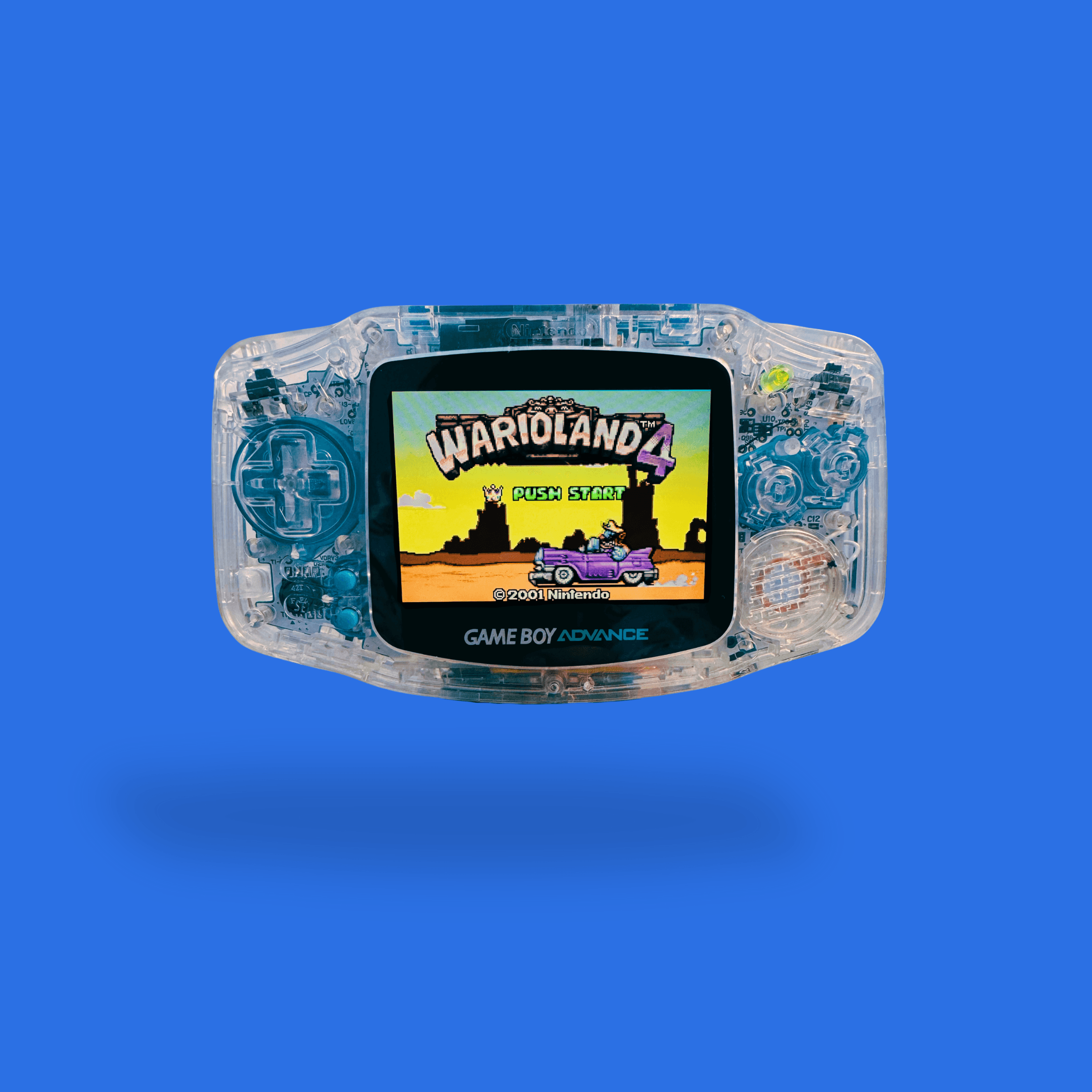 A RetroGear-modded transparent Nintendo Game Boy Advance with blue details and the game Wario Land 4 visible on the screen.